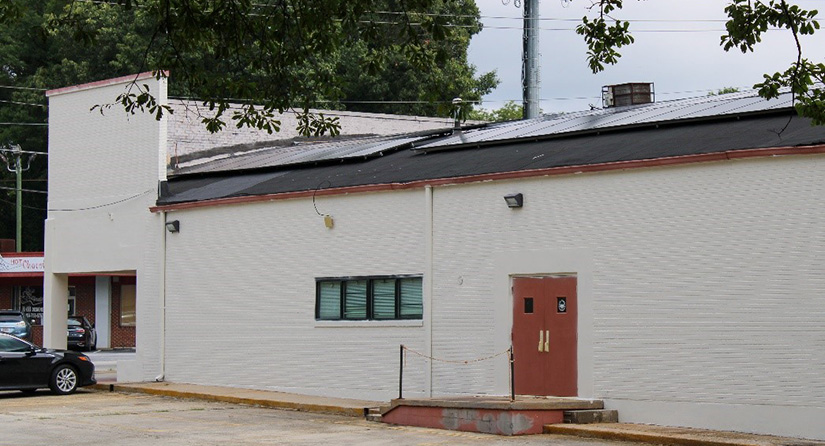 A one-story building with solar panels on the roof.