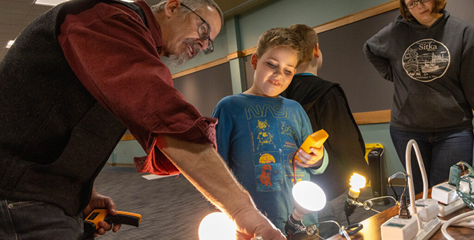 Adult teaches kids how electricity and lights work