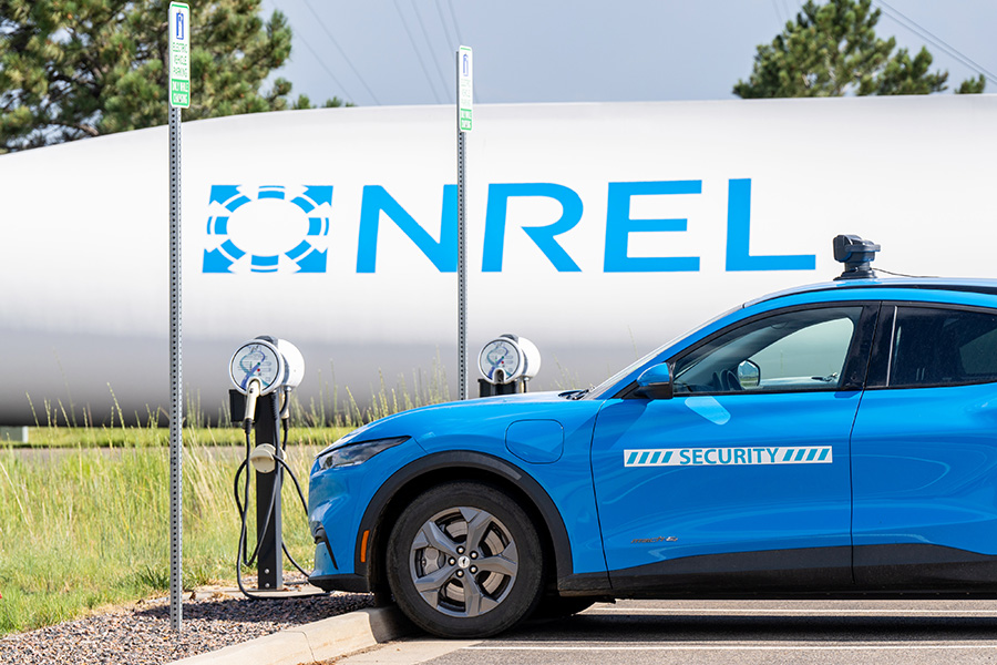 An electric NREL security vehicle at a charging station.