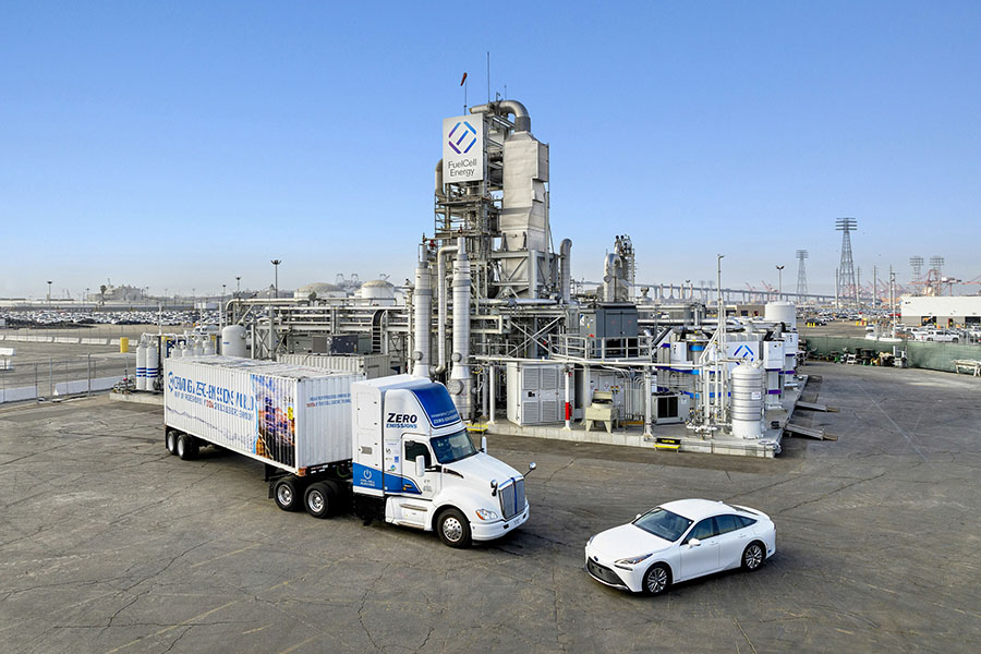 A zero-emissions, semi-truck and car in front of a FuelCell Energy plant