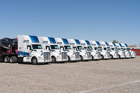 A line of trucks with trailers.