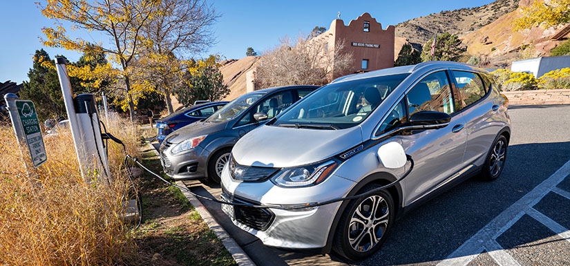 Electric vehicles charging in a parking lot.