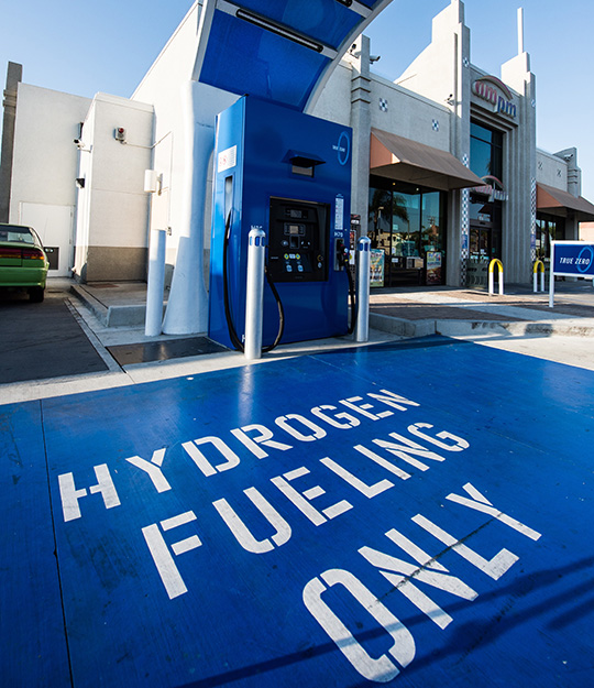 A hydrogen fueling station with the ground painted blue and text painted on reading hydrogen fueling only.