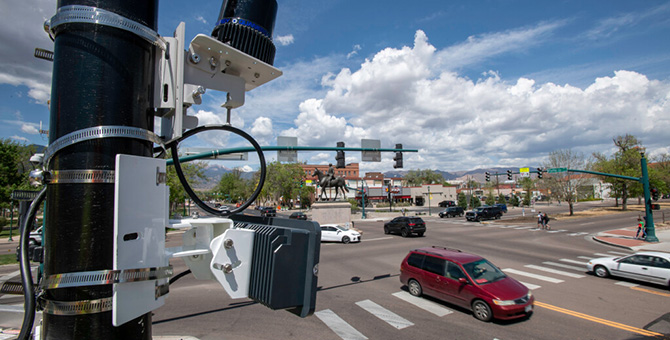 Traffic sensing equipment mounted on a traffic light pole above an intersection.