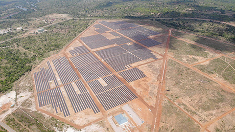 Aerial view of solar panel array on ground.