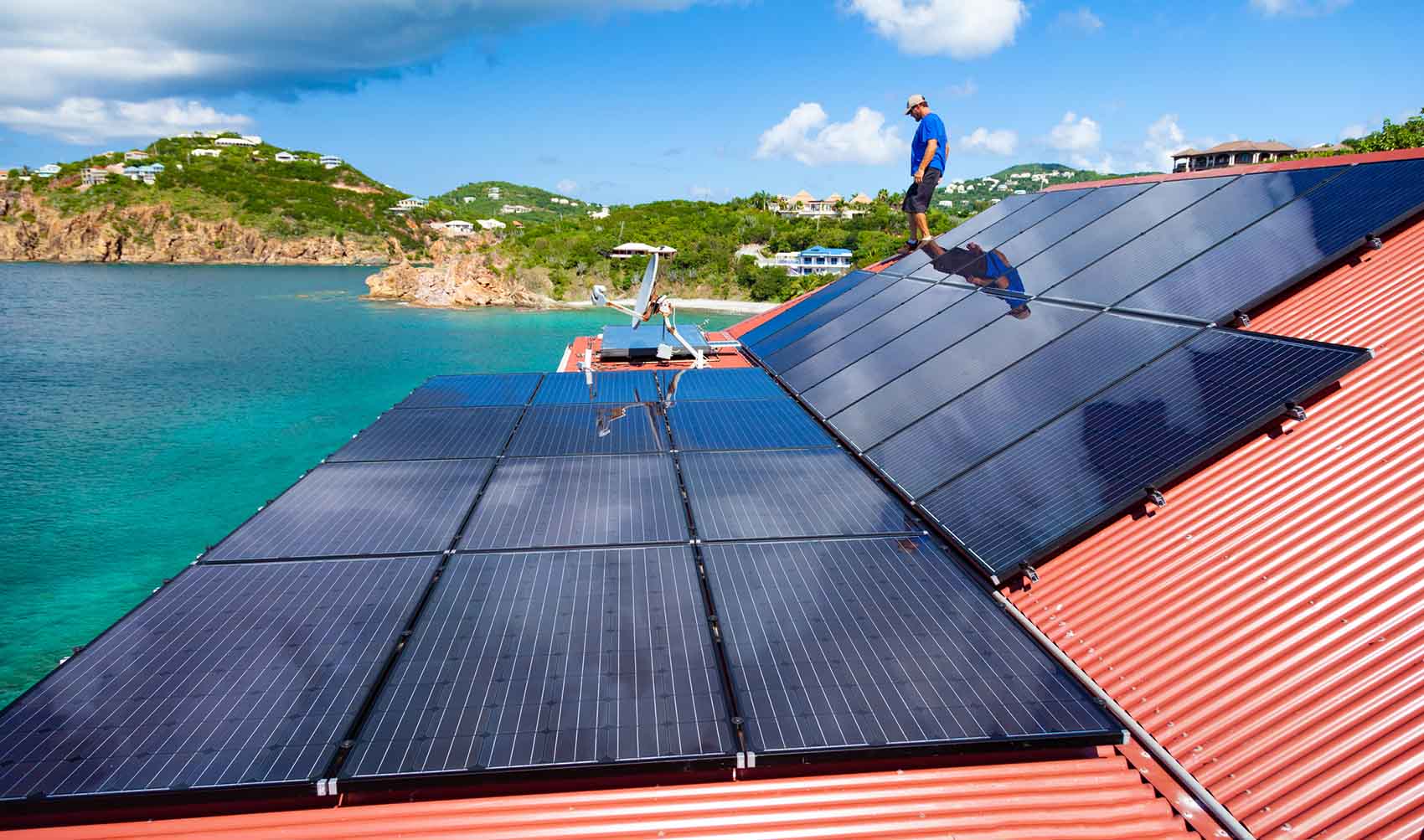 Person walks on rooftop solar panels.