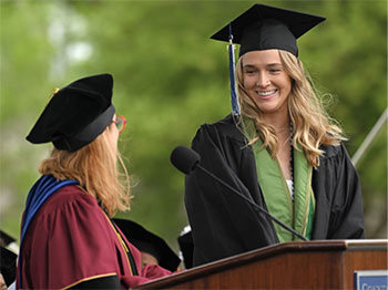 Sarah Hall in a cap and gown at a commencement ceremony