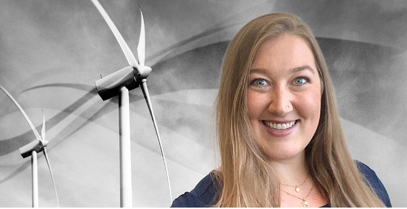 Lanaia Carveth in front of two wind turbines
