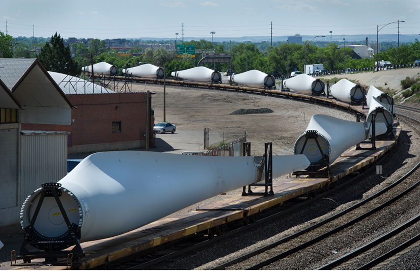 Multiple wind turbine blades transported on a train